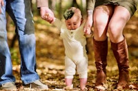 a family with a baby walking in the woods