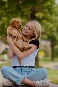 a woman is holding a dog