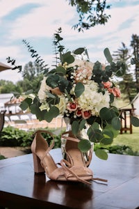 a bouquet of flowers and a pair of shoes on a table