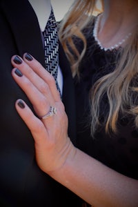 a man wearing a suit and tie and a ring on his finger