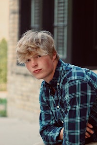 a young man wearing a plaid shirt