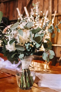 eucalyptus and eucalyptus flowers in a glass vase on a wooden table