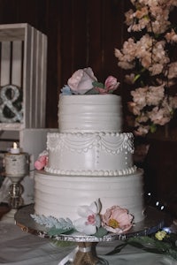 a white wedding cake sits on top of a table